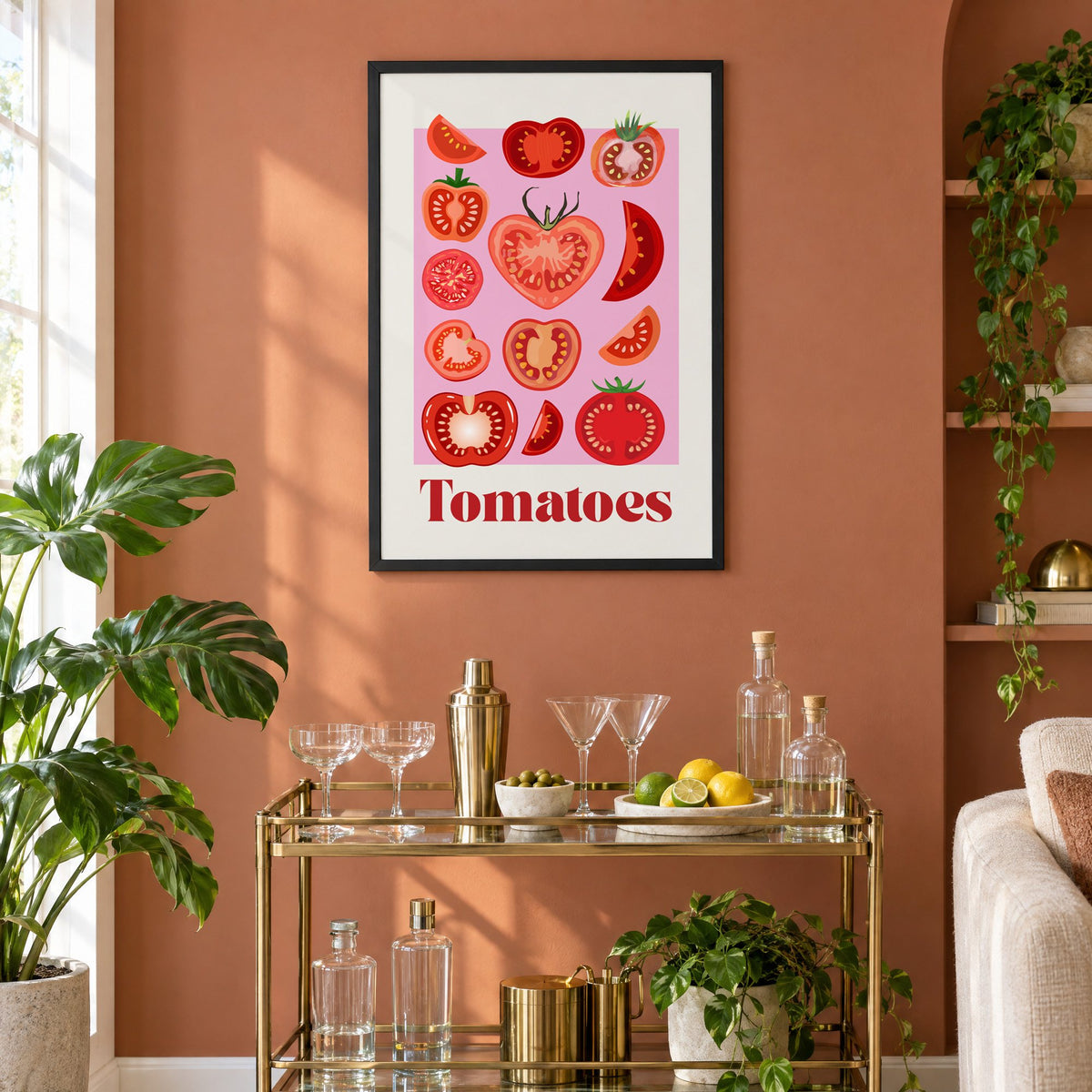 Tomatoes bold serif pink panel tomato chart print in a black frame on a terracotta wall above a brass bar cart with coupes and citrus