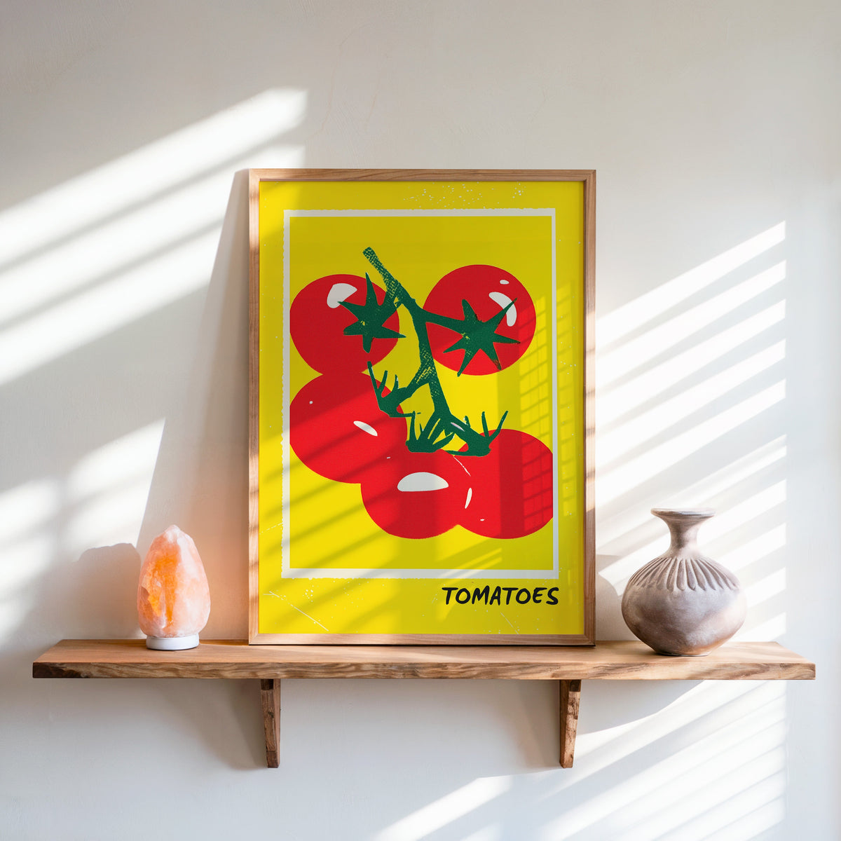 Tomatoes print in an oak frame on a live-edge shelf beside a salt lamp