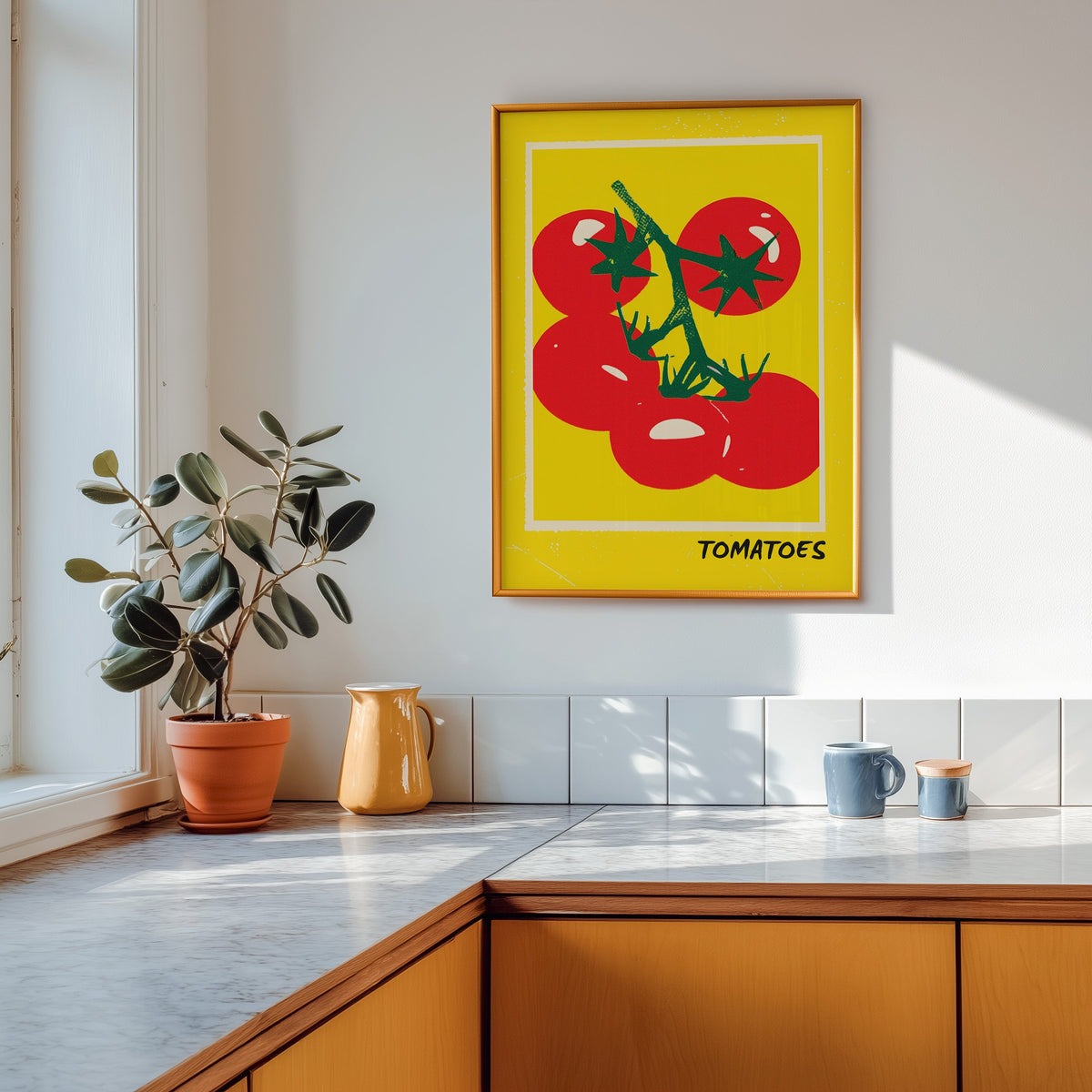 Tomatoes print shown in a gold frame above a marble counter in a tan kitchen