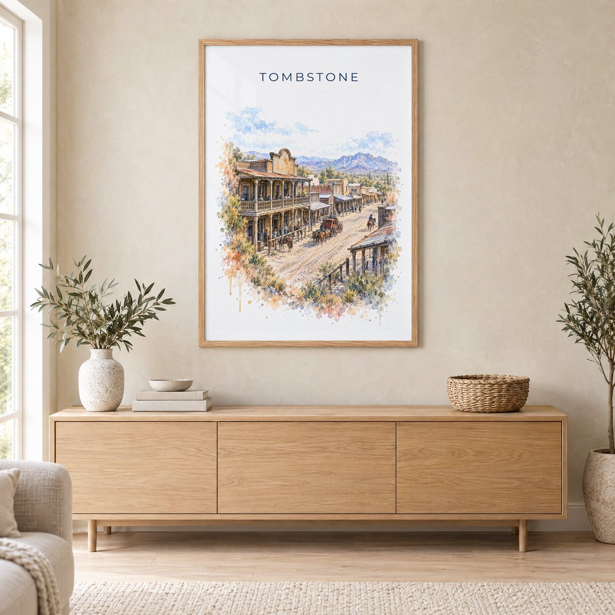 Tombstone, Arizona watercolor print in an oak frame above a light wood sideboard in a Scandinavian living room