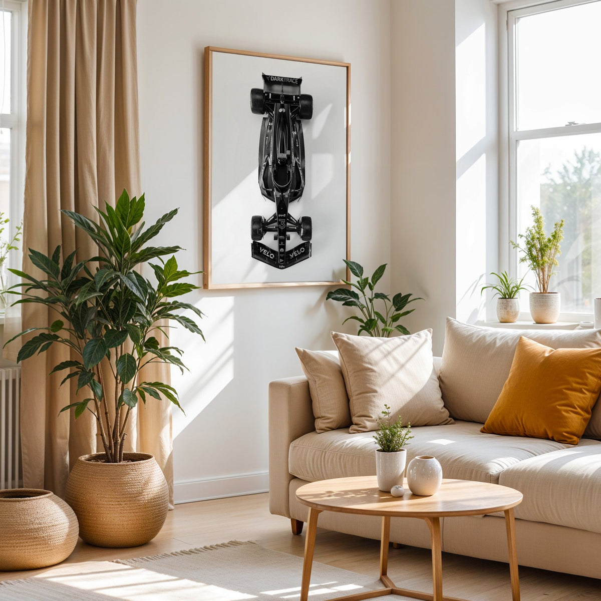 Top view black formula-style race car print in an oak frame above a cream sofa beside woven planters