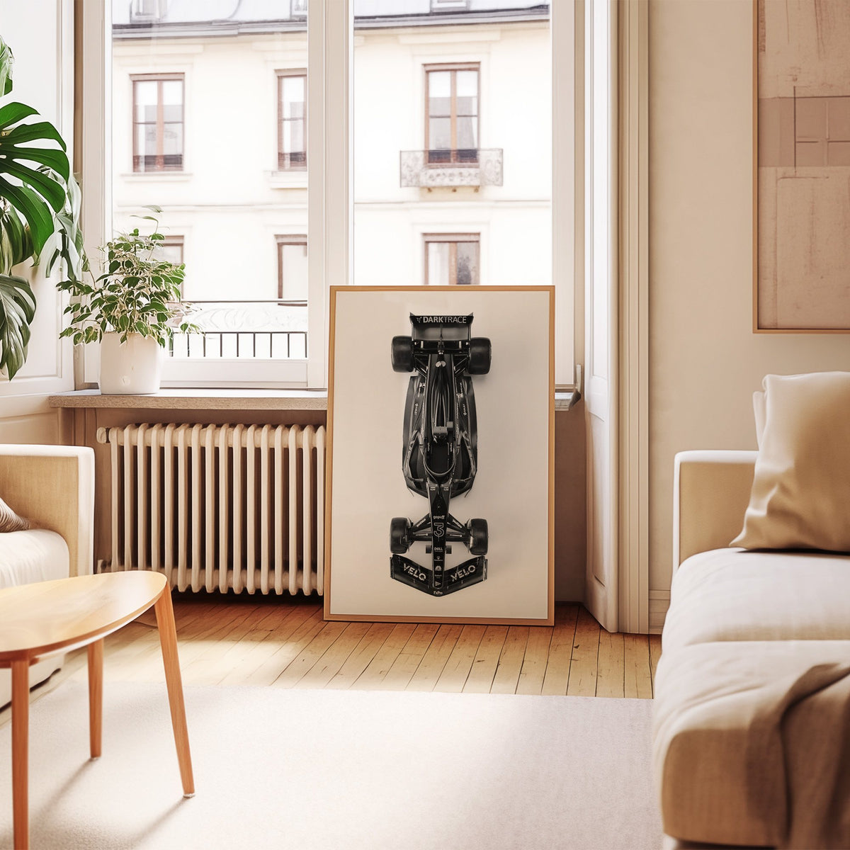 Top view black formula-style race car print in an oak frame leaning by a French window in a living room