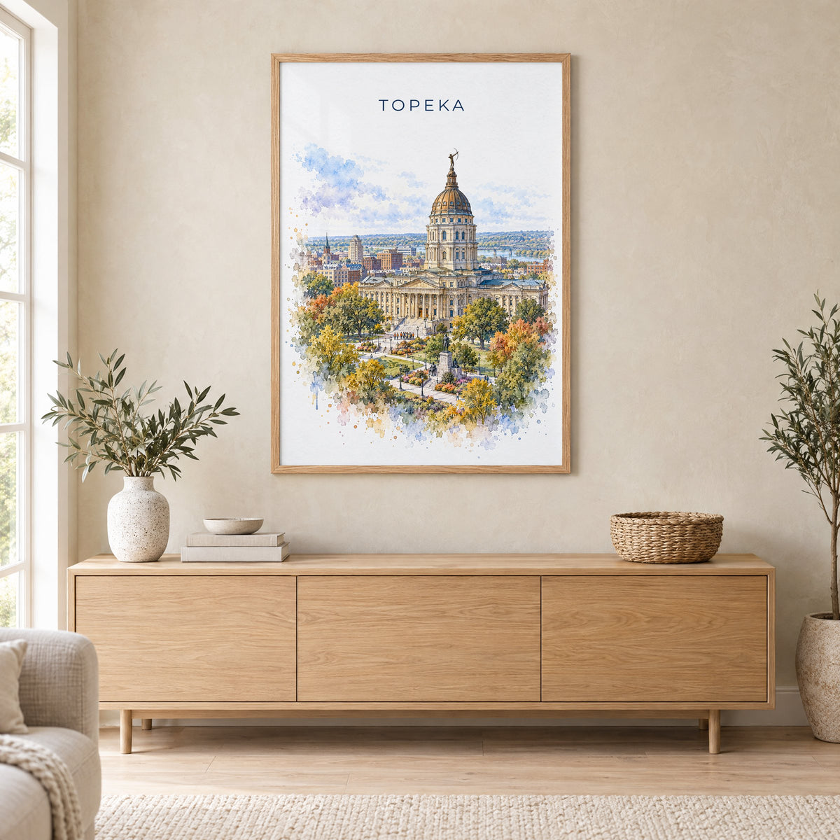 Topeka watercolor print in an oak frame above a light wood sideboard in a Scandinavian living room