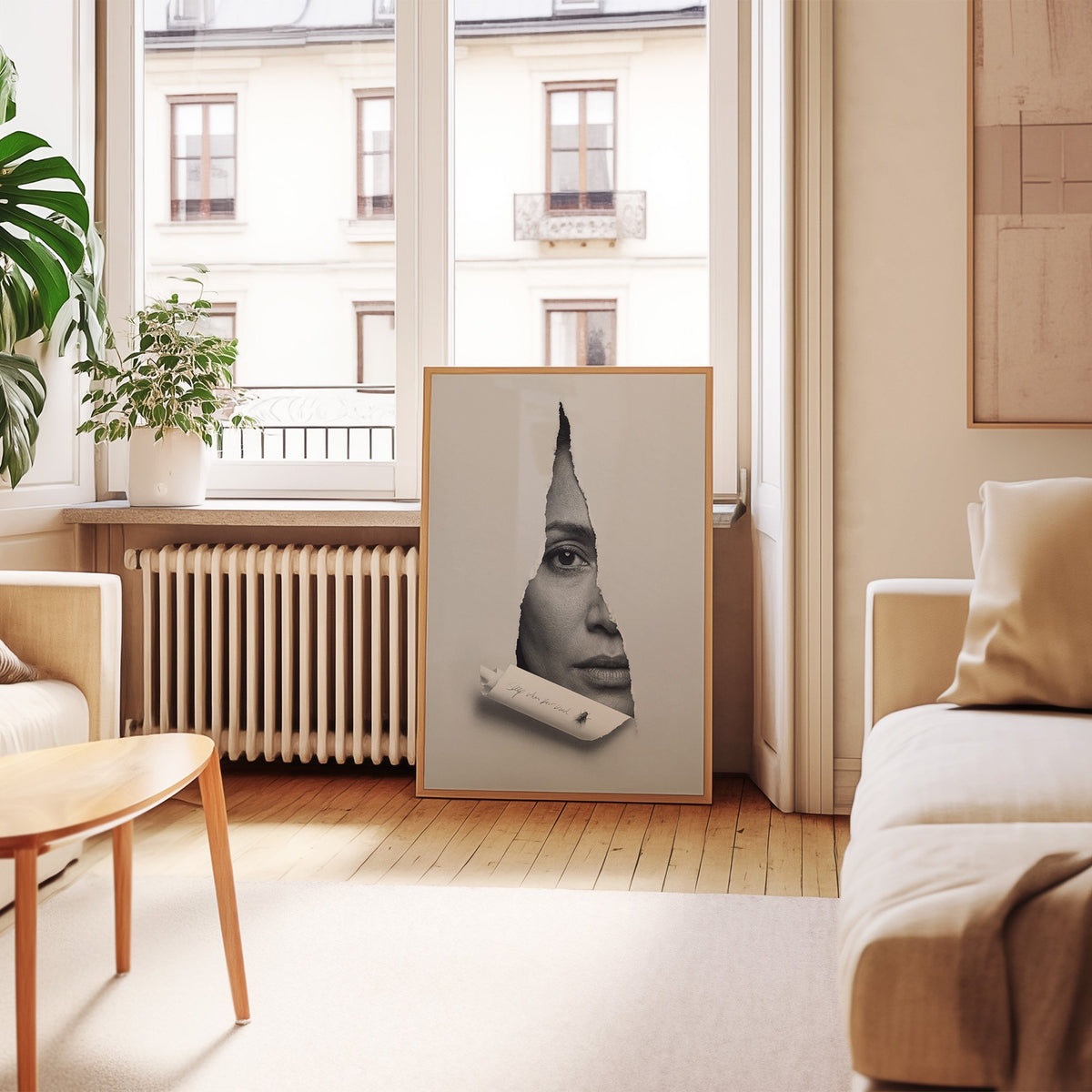 Half face behind torn grey paper slit print in an oak frame leaning by a French window in a living room