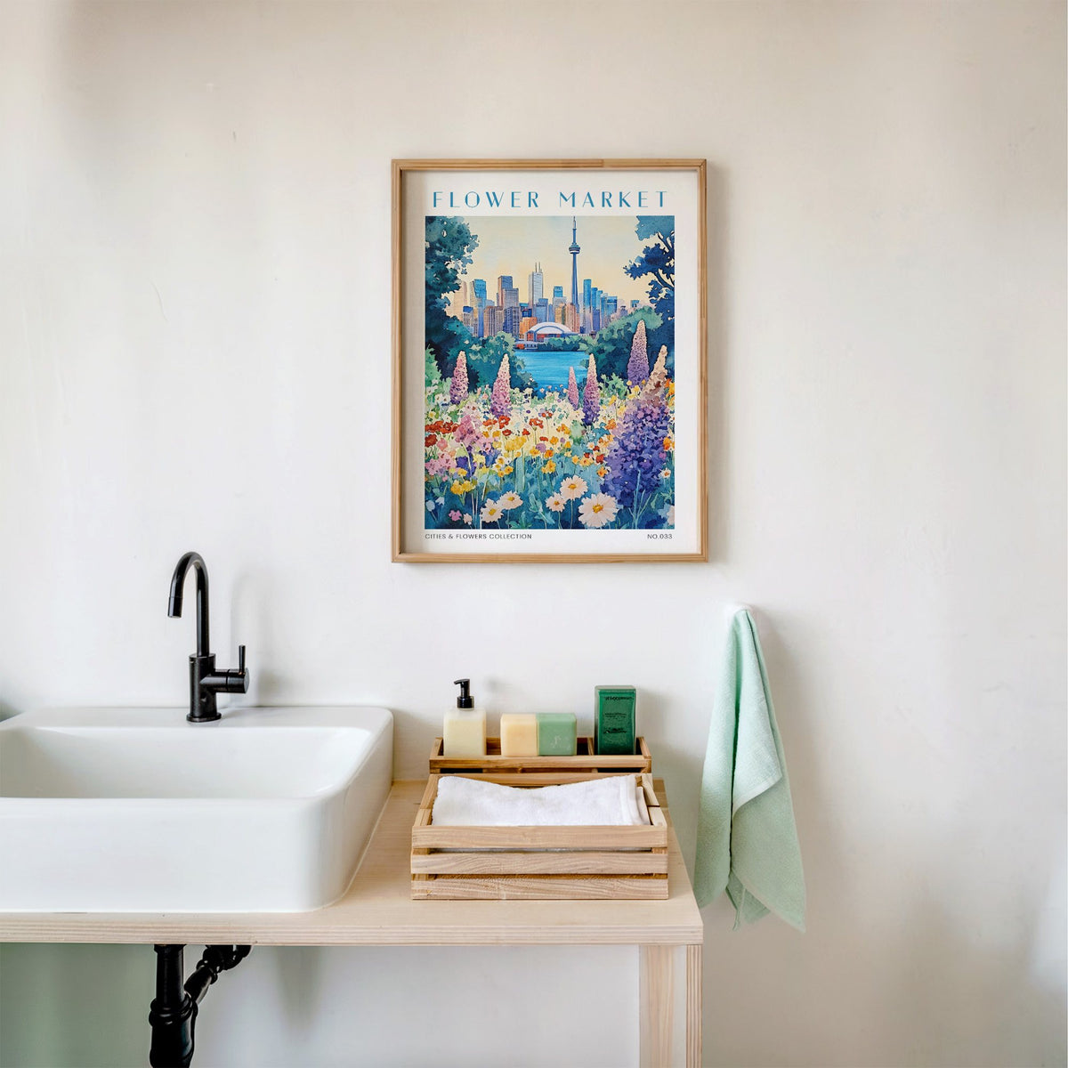 Toronto flower market print in an oak frame above a white bathroom sink with folded towels