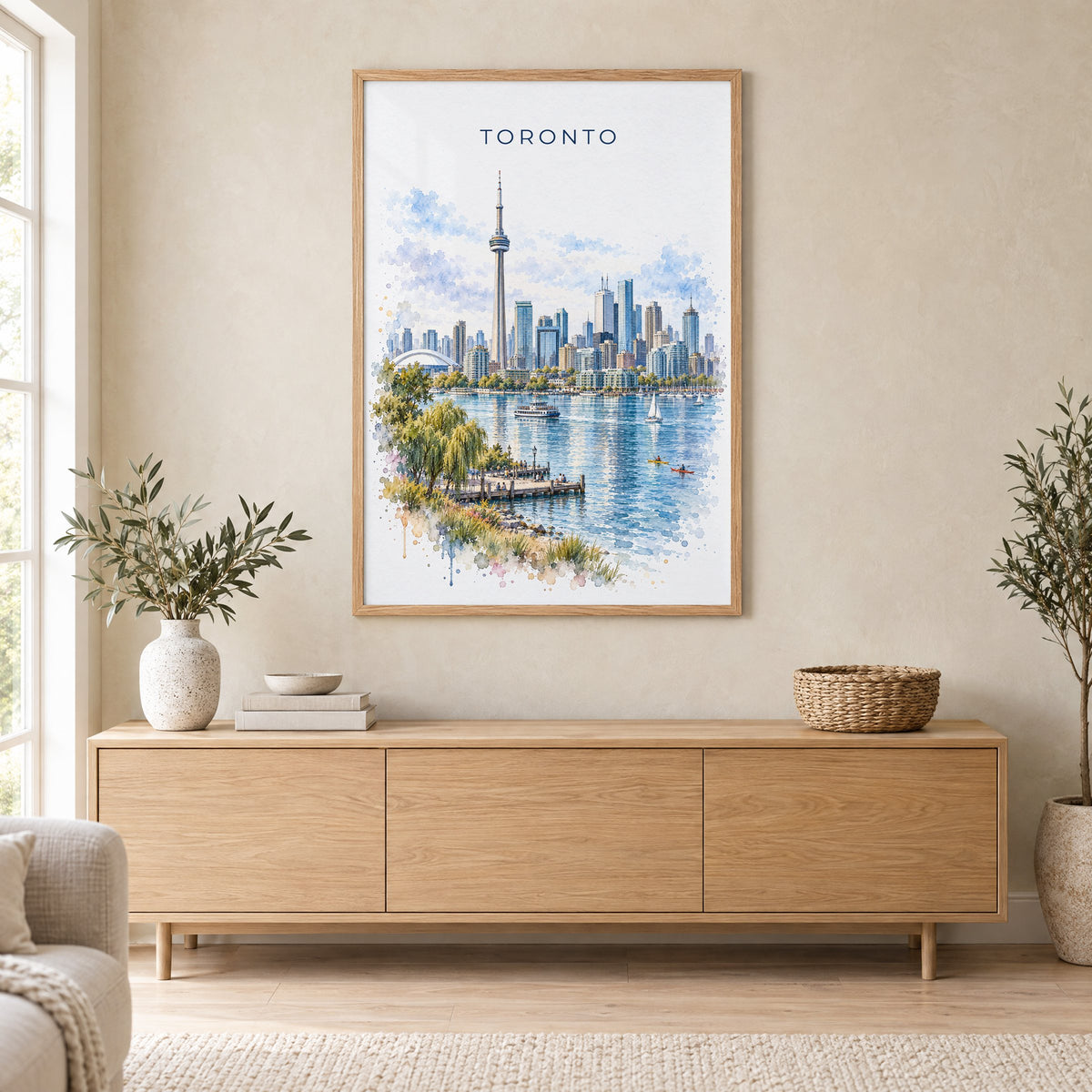 Toronto watercolor print in an oak frame above a light wood sideboard in a Scandinavian living room