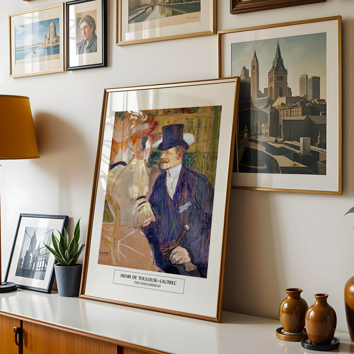Belle Époque Paris print shown in a gold frame leaning on a sideboard in a gallery wall