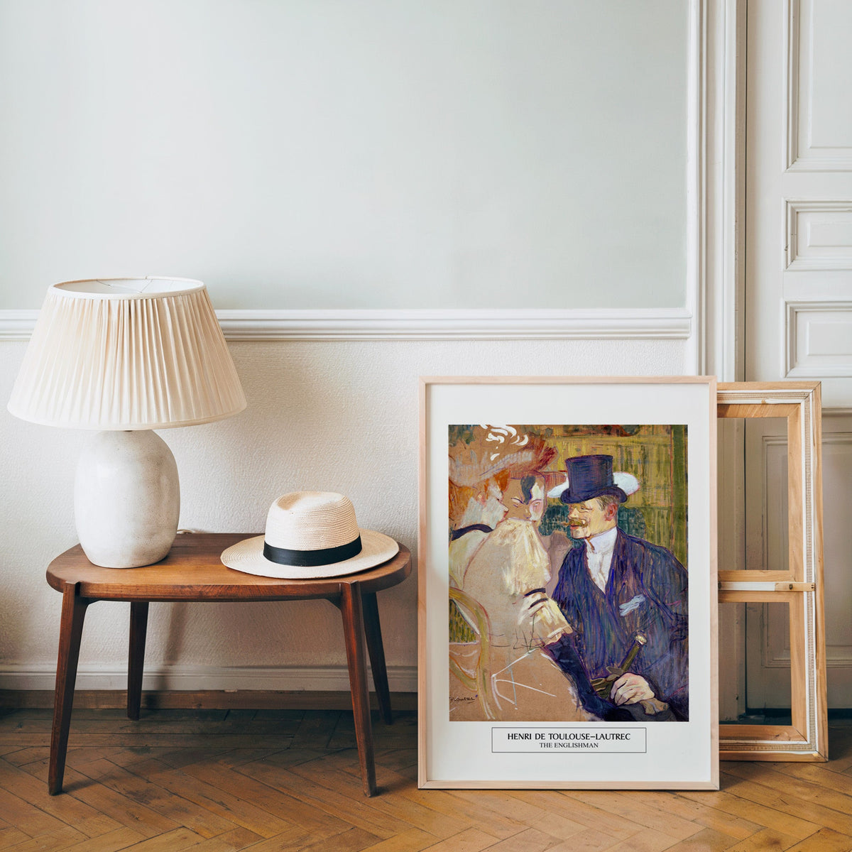 Post-impressionist Paris poster in a light wood frame leaning by a bench and hat