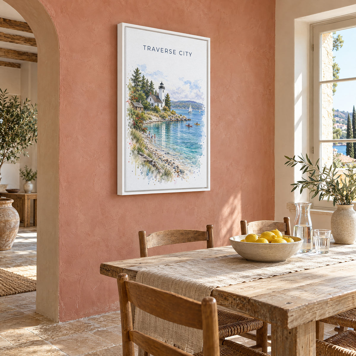 Traverse City watercolor print as a white floater canvas on a terracotta wall above a rustic dining table