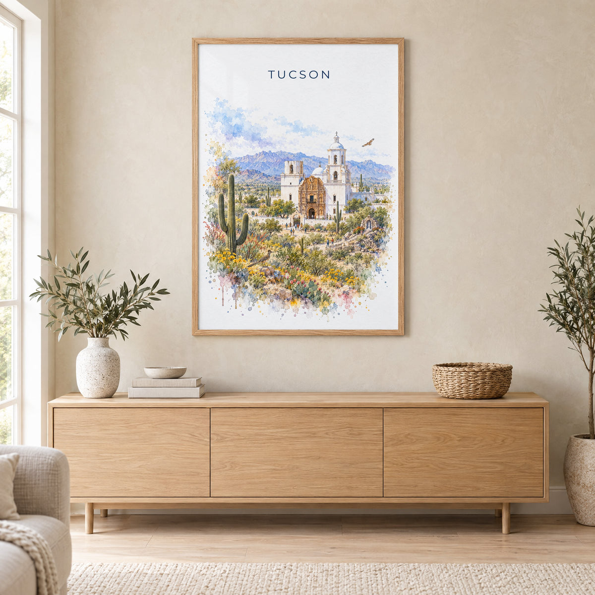 Tucson watercolor print in an oak frame above a light wood sideboard in a Scandinavian living room