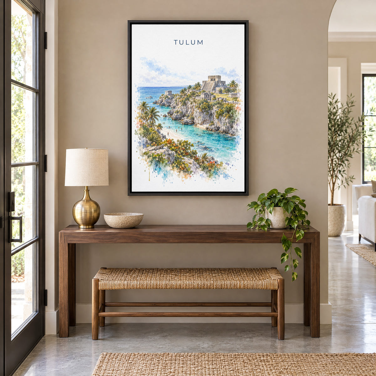 Tulum watercolor print as a black floater canvas above a walnut console and woven bench in an entryway