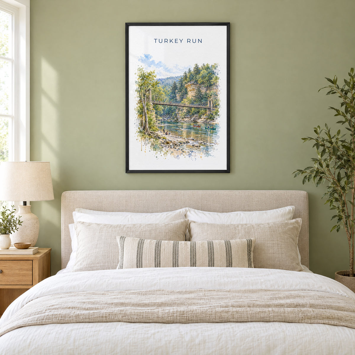 Turkey Run State Park watercolor print in a black frame above an upholstered headboard in a sage green bedroom