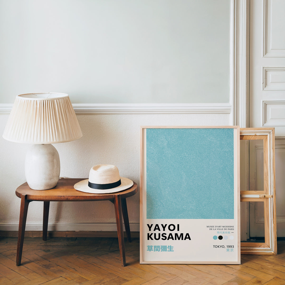 Yayoi Kusama inspired turquoise dotted texture print beside a bench and straw hat