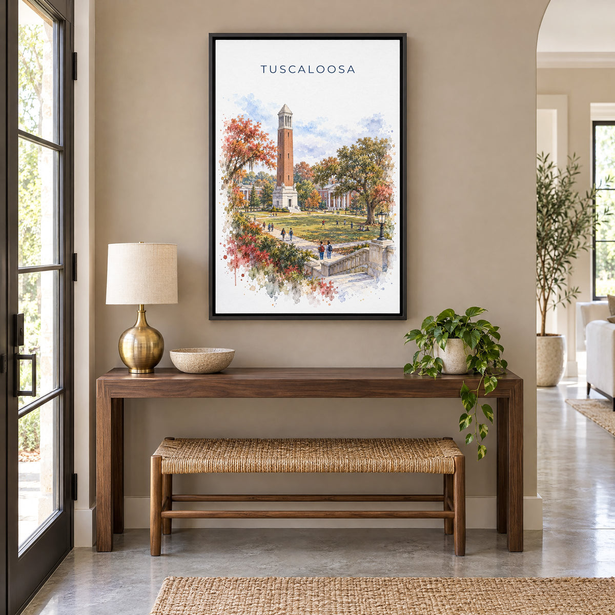 Tuscaloosa watercolor print as a black floater canvas above a walnut console and woven bench in an entryway