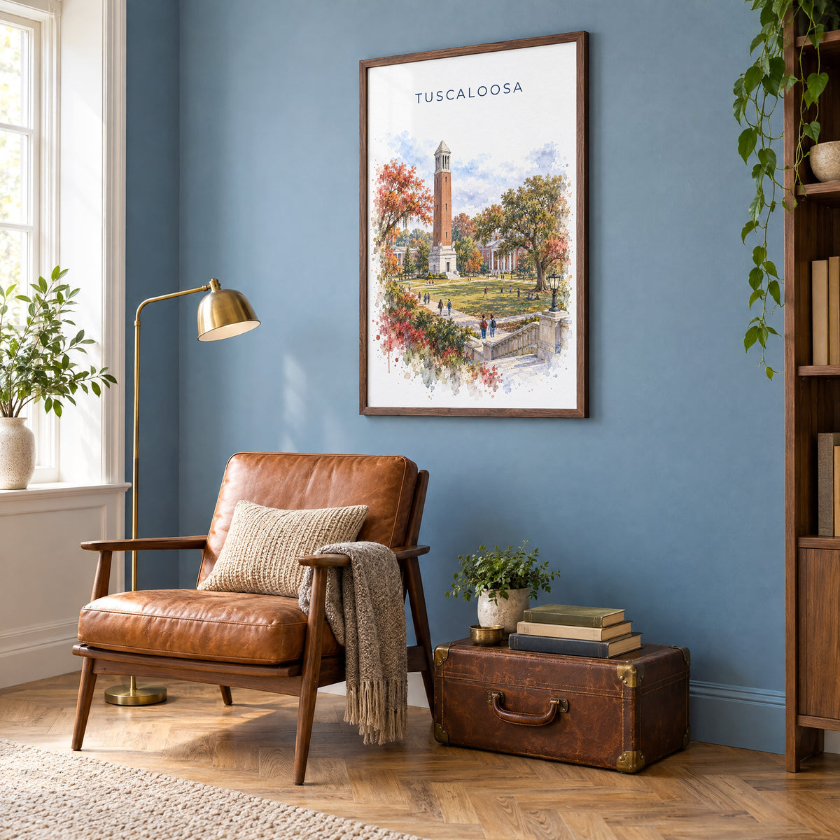 Tuscaloosa watercolor print in a walnut frame on a blue wall above a leather armchair in a reading nook