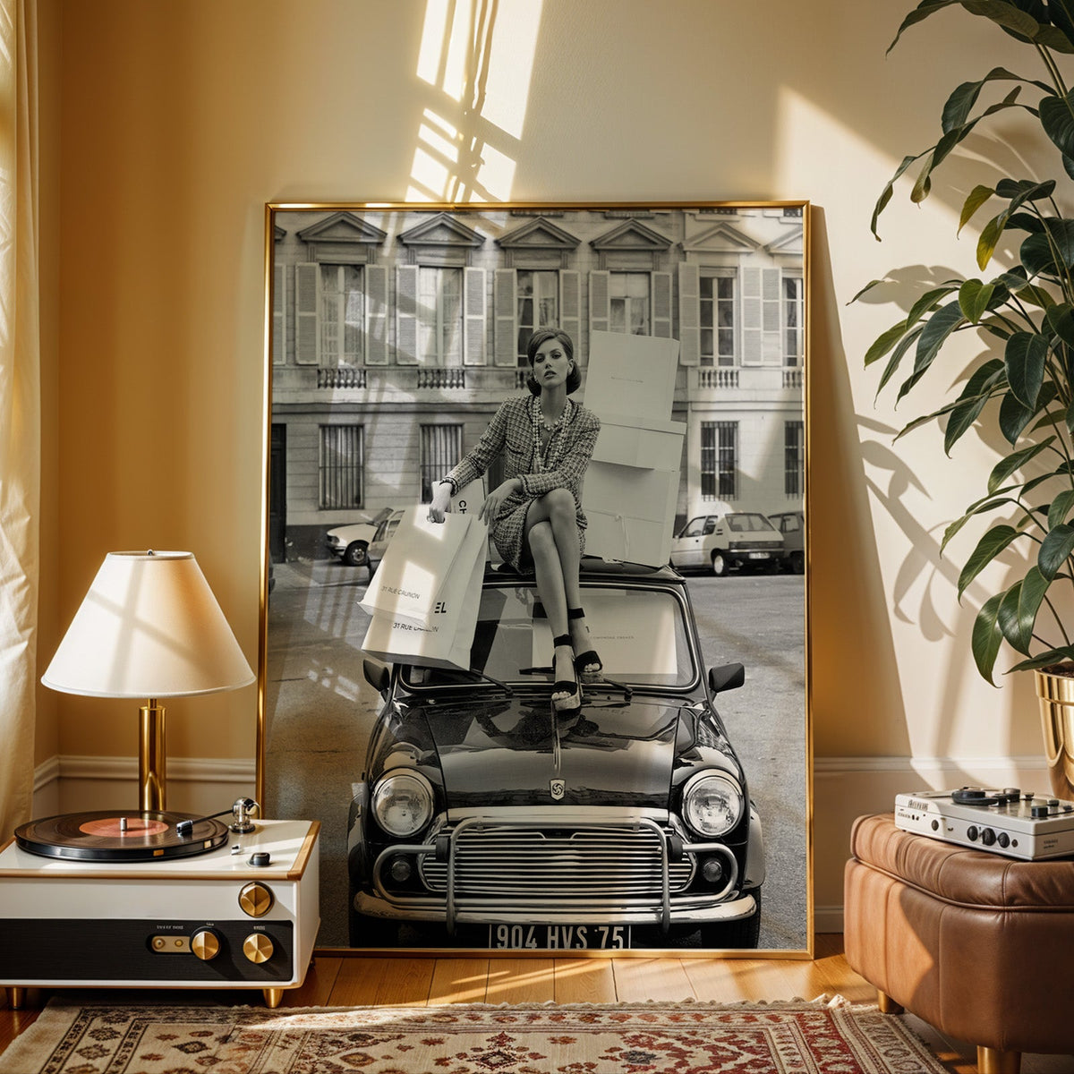 Woman in tweed suit with boxes and small car print shown in a gold frame beside a record player and table lamp