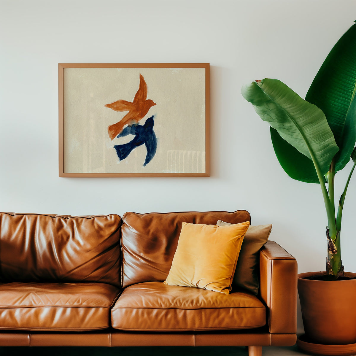 Rust and navy bird print in an oak frame above a cognac leather sofa