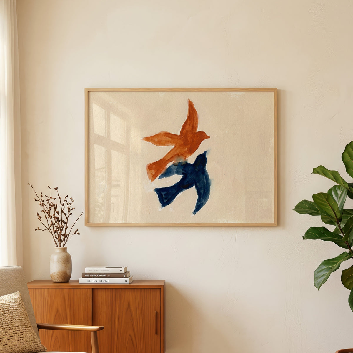 Birds in flight print in an oak frame above a teak sideboard beside a fig tree