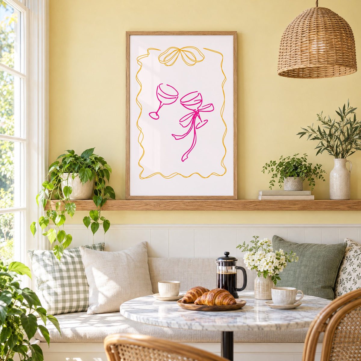 Two coupes pink bow ribbon frame print in an oak frame on a picture ledge above a sunny breakfast nook