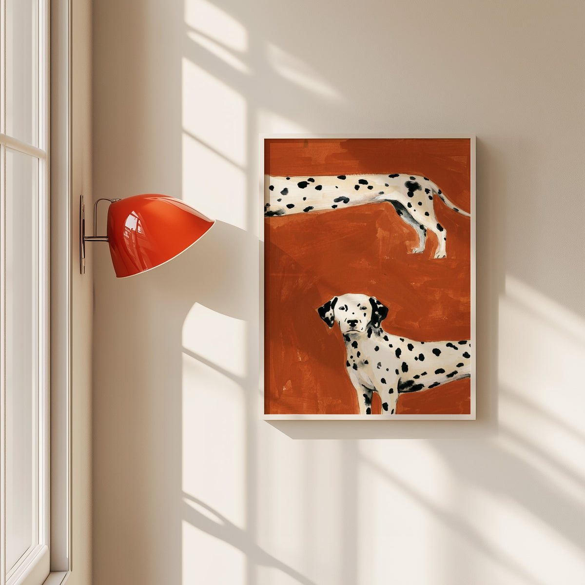 Two Dalmatians print in a white frame beside a red wall sconce