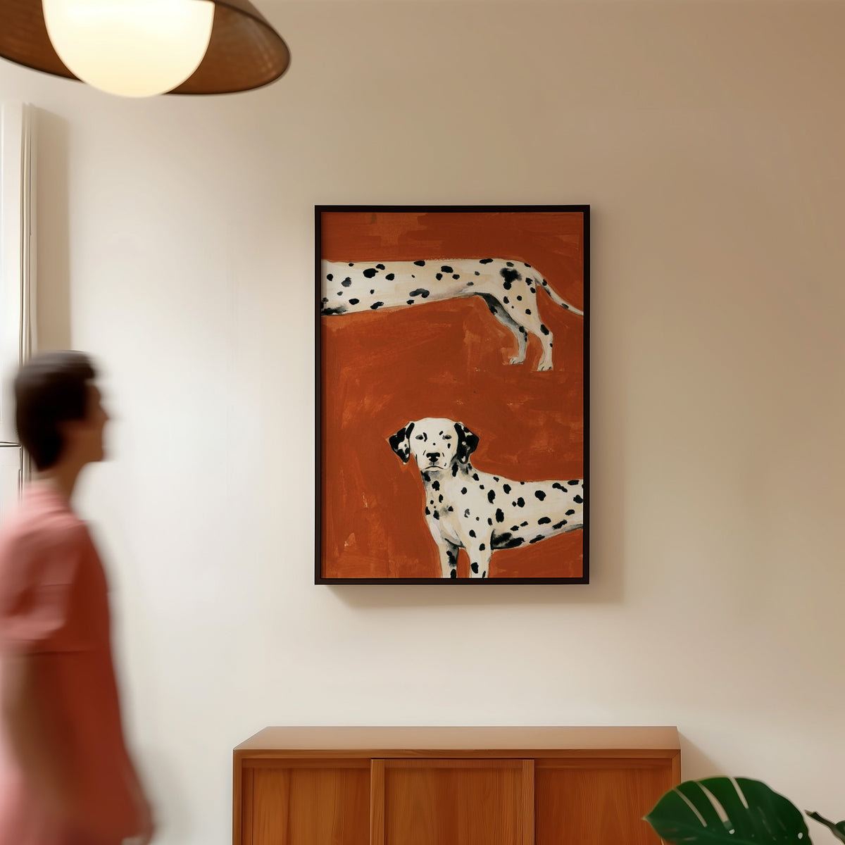 Dalmatian dog wall art print in a black frame in a hallway under a rattan pendant