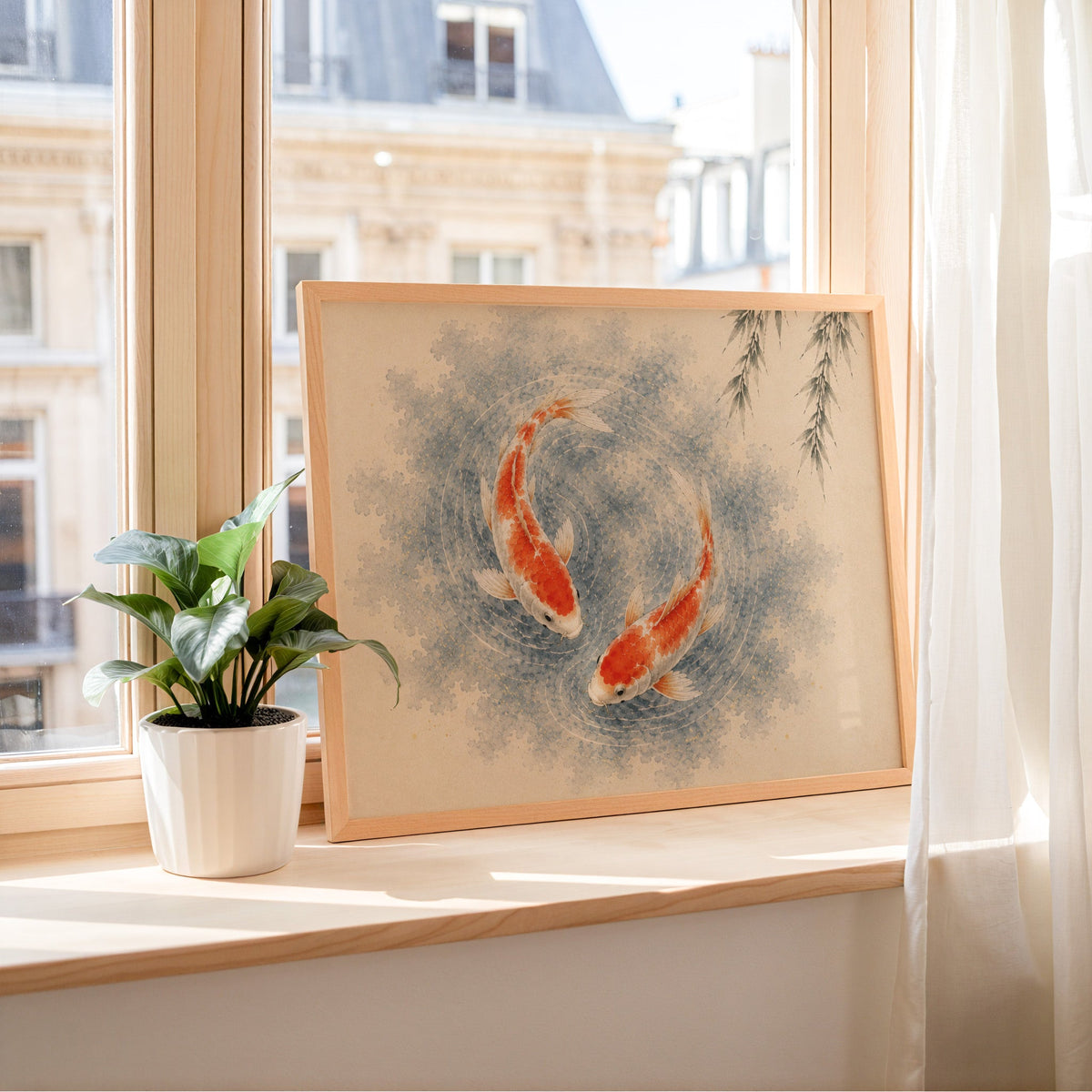 Two koi circling under a willow print in a light wood frame leaning on a sunny windowsill by sheer curtains