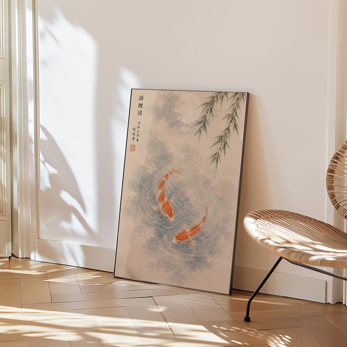 two koi with willow and moon print in a black frame leaning on a herringbone floor beside a woven rattan chair