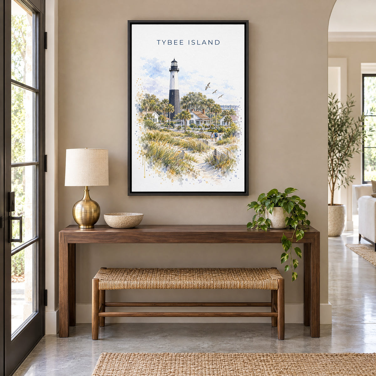Tybee Island watercolor print as a black floater canvas above a walnut console and woven bench in an entryway