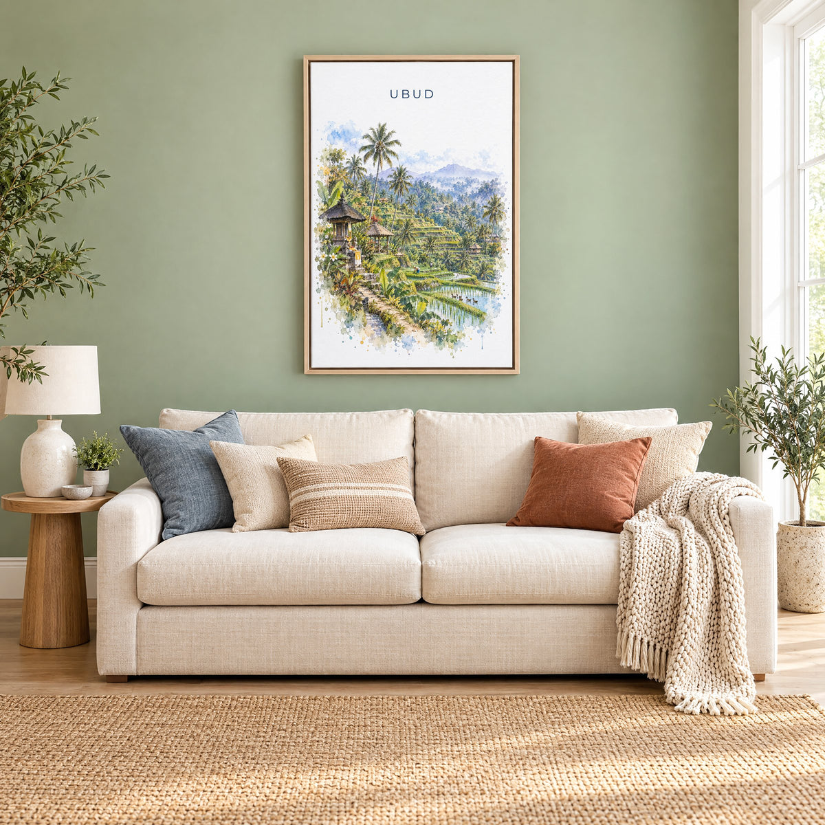 Ubud watercolor print as a natural floater canvas above a cream linen sofa on a sage green wall