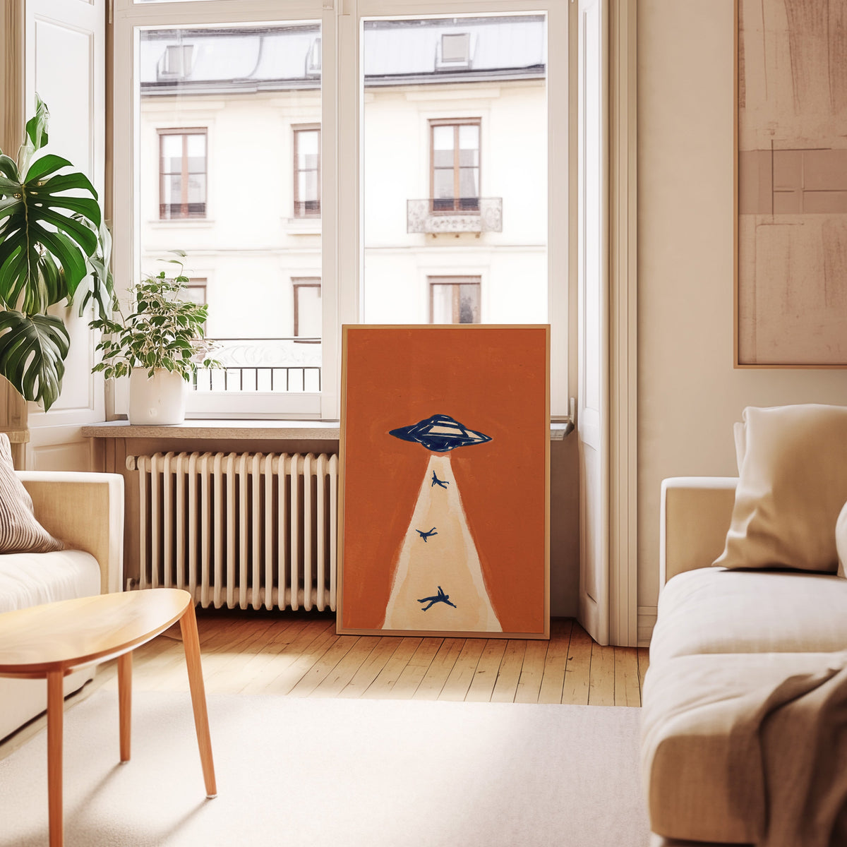 Flying saucer print in an oak frame leaning below tall French windows