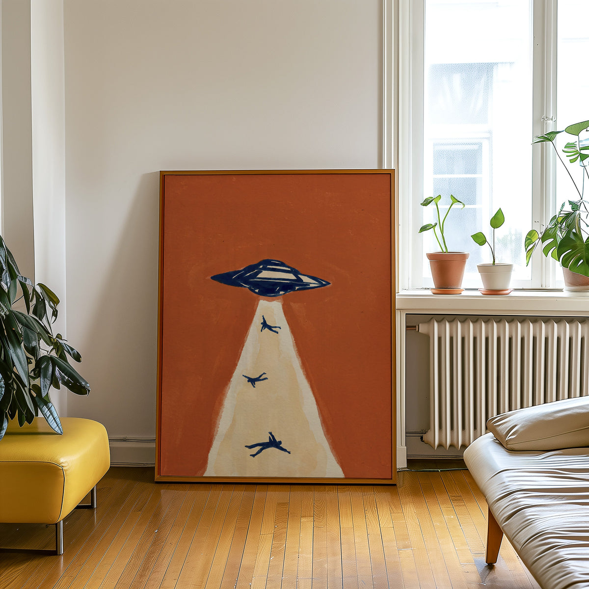 Alien abduction wall art print in an oak frame leaning beside a yellow leather bench