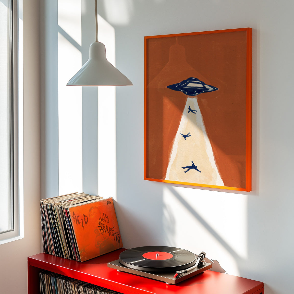 Flying saucer print shown in an orange frame above a red record cabinet and turntable