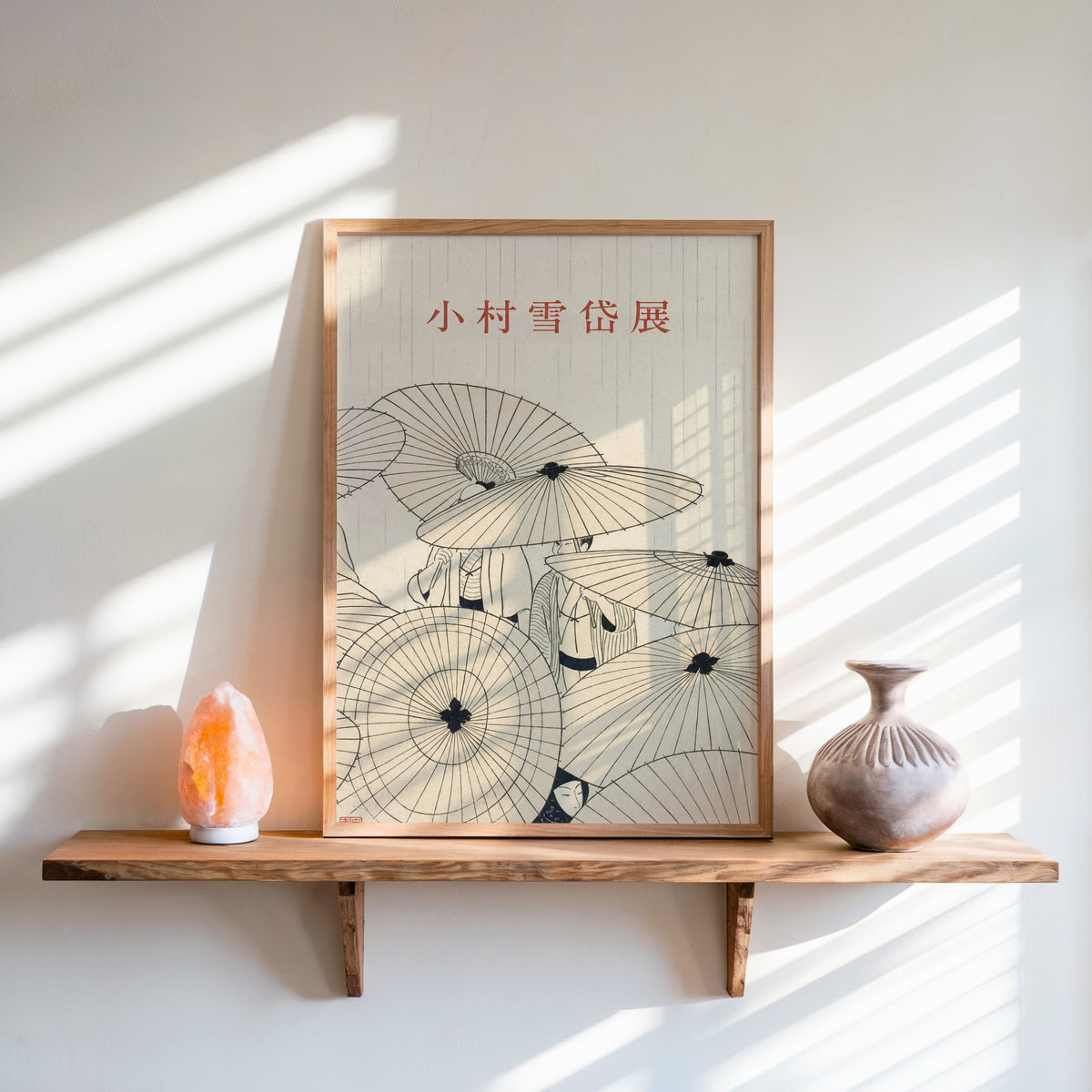 paper umbrellas in the rain line art print in an oak frame on a live-edge wall shelf with a salt lamp and clay vase
