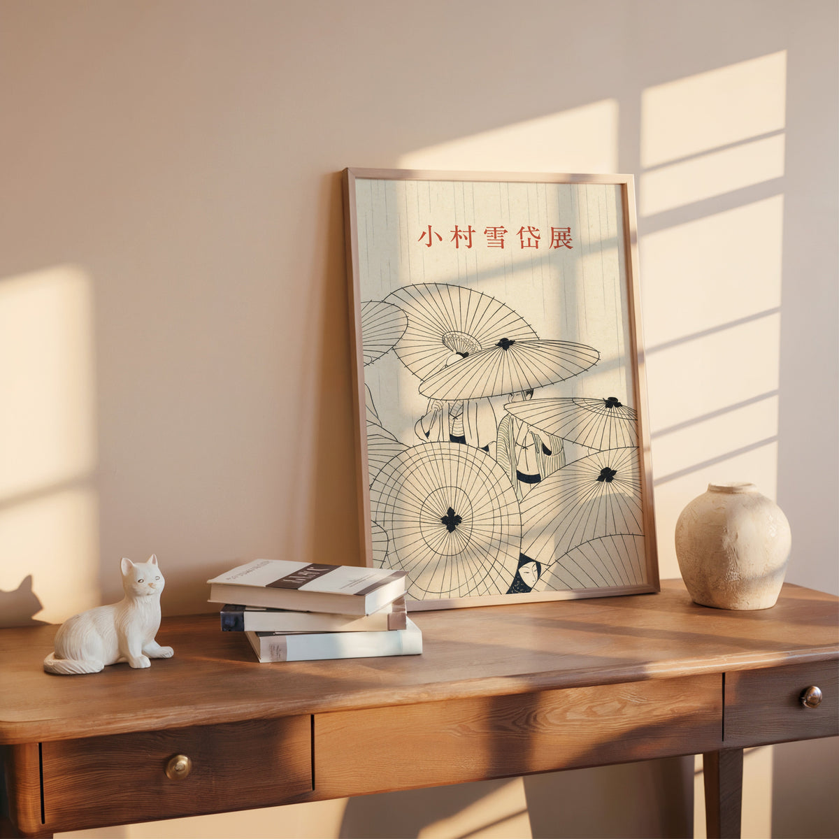 paper umbrellas in the rain line art print shown in a rose gold frame leaning on a wooden writing desk with books
