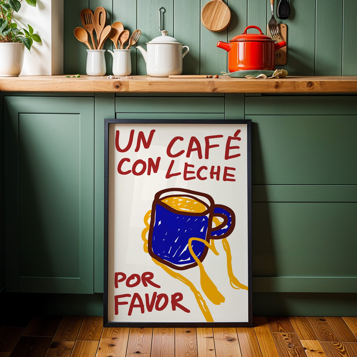 Un cafe con leche print in a black frame against sage green kitchen cabinets
