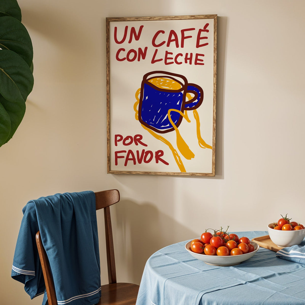 Un cafe con leche print in an oak frame above a blue linen table with ripe tomatoes