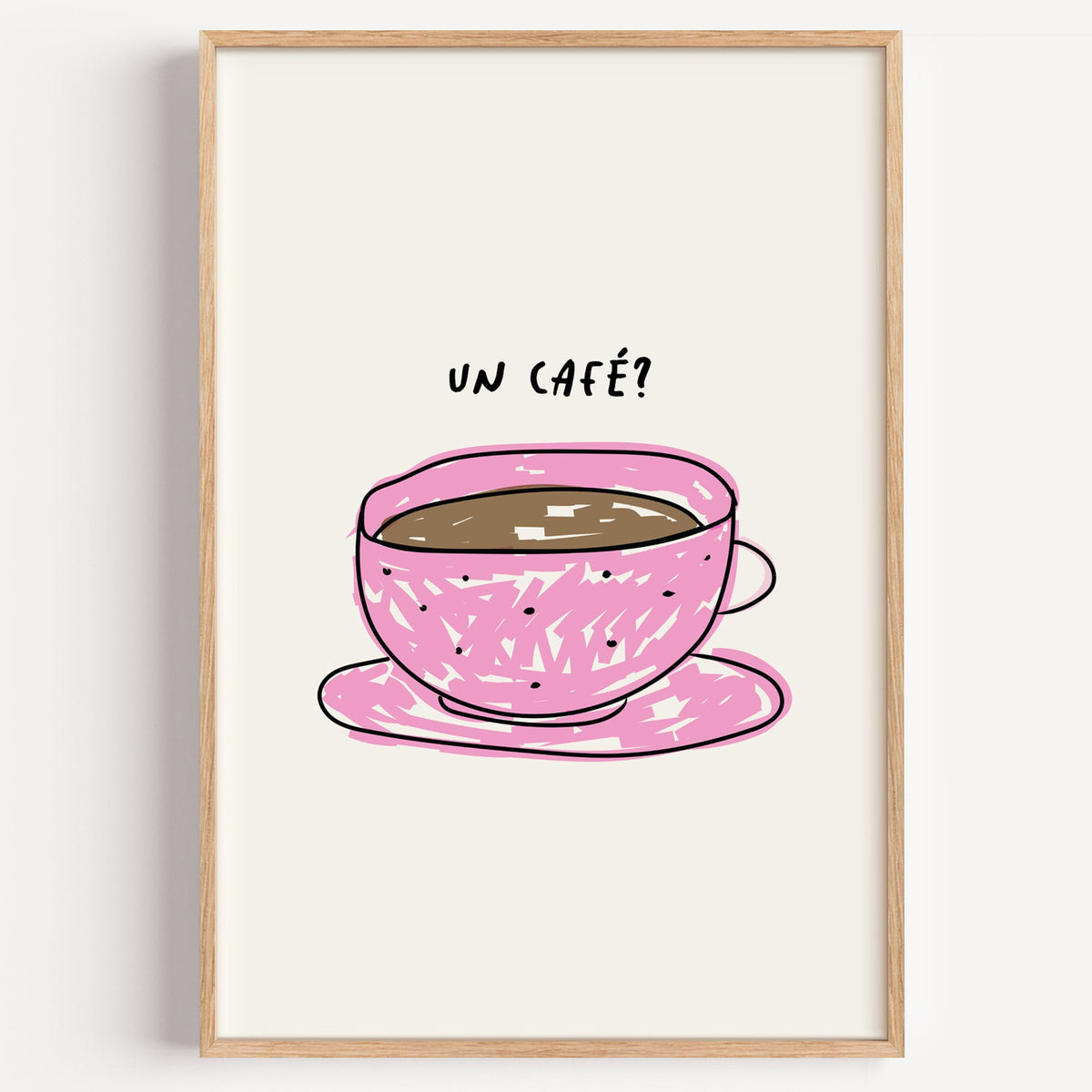 Un cafe pink cup print in a light oak frame on a plain white wall