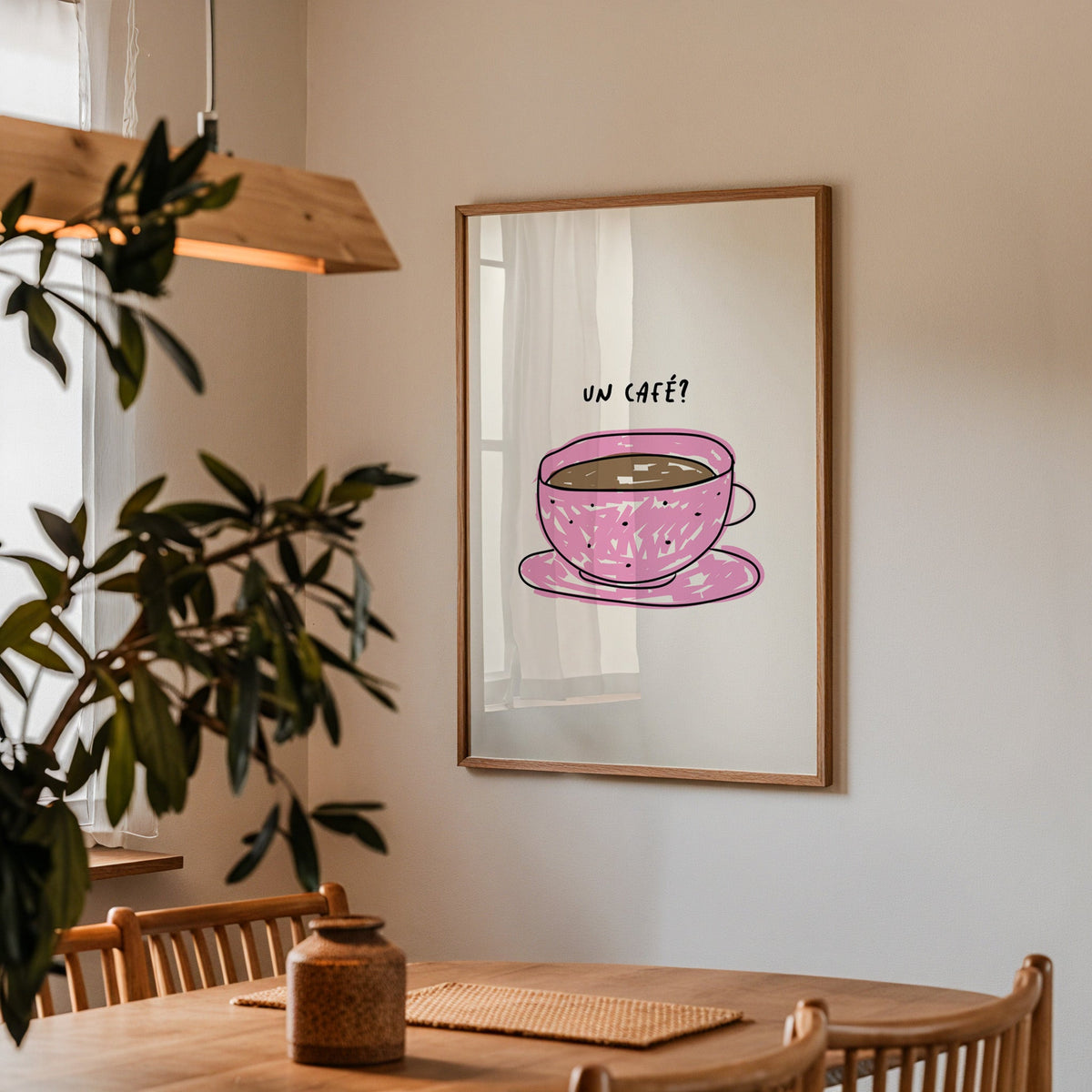 Un cafe pink cup print in a walnut frame above a dining table beside an olive tree