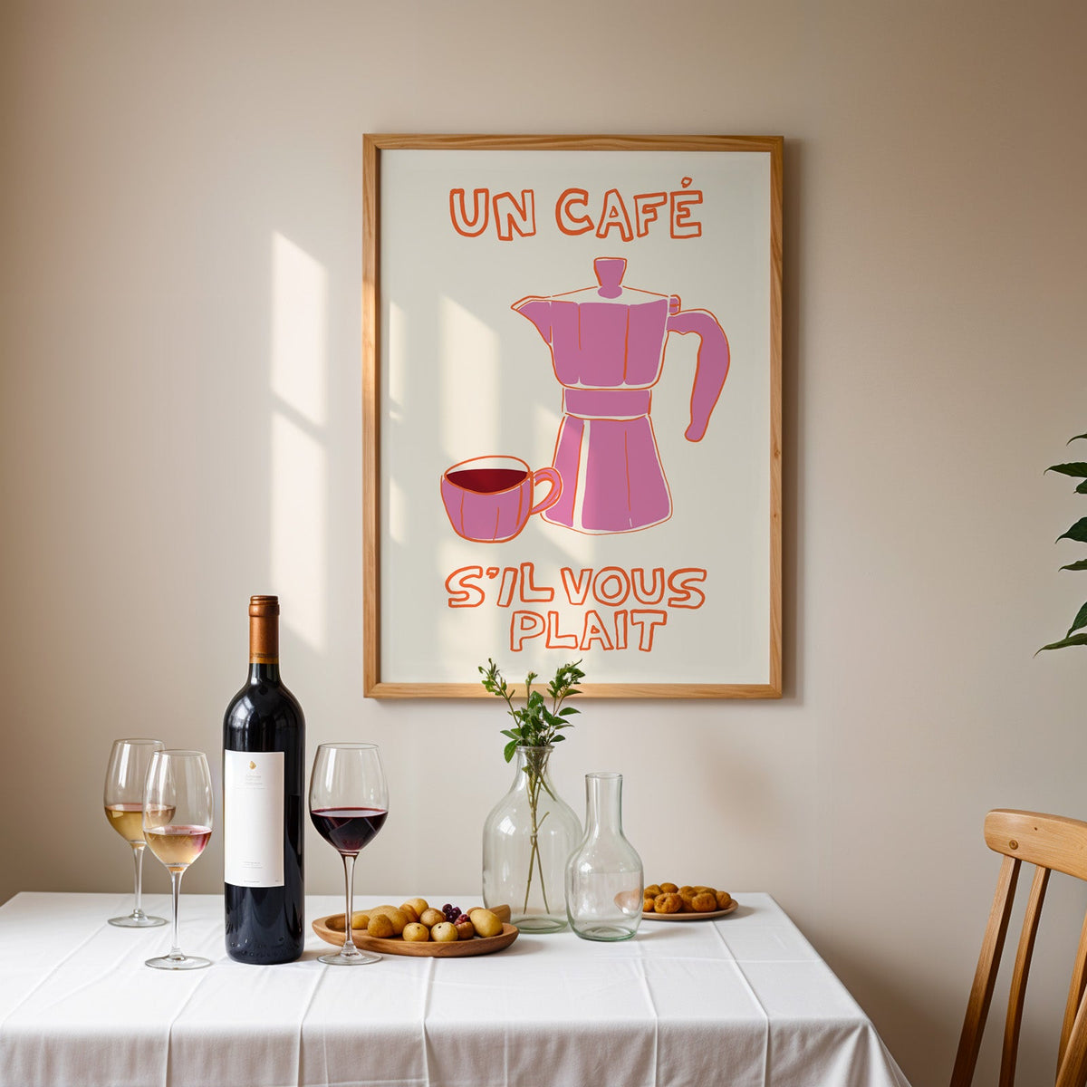 Un cafe pink moka pot print in an oak frame above a table laid with red wine