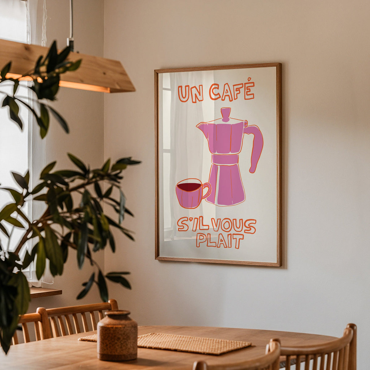 Un cafe pink moka pot print in a walnut frame above a table beside an olive tree