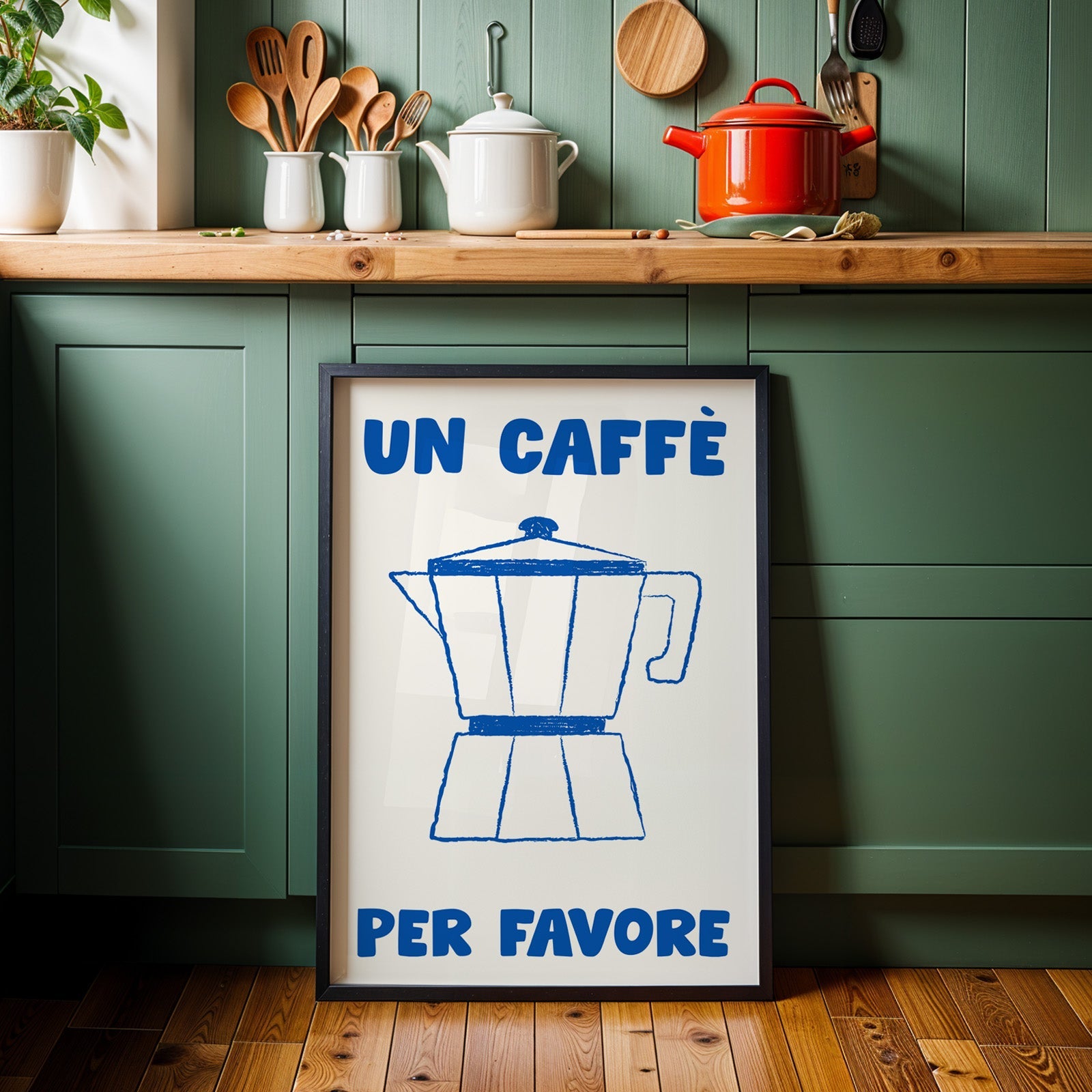 Un caffe per favore moka pot print in a black frame against sage green cabinets