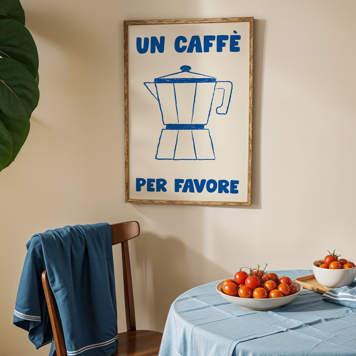 Un caffe per favore moka pot print in an oak frame above a blue linen table
