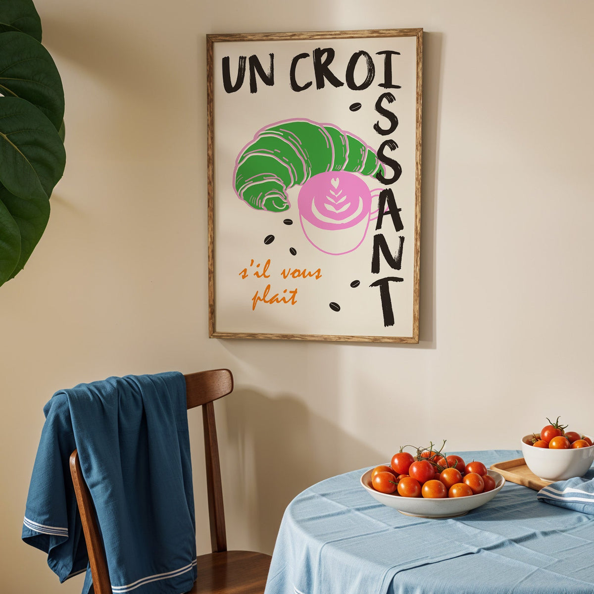 Un croissant french bakery print in an oak frame above a blue linen table