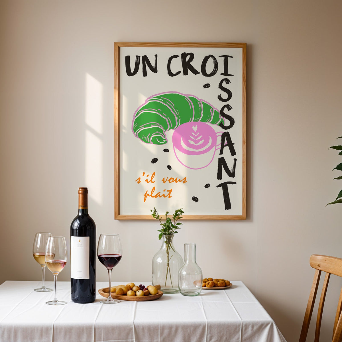 Un croissant french bakery print in an oak frame above a table laid with red wine