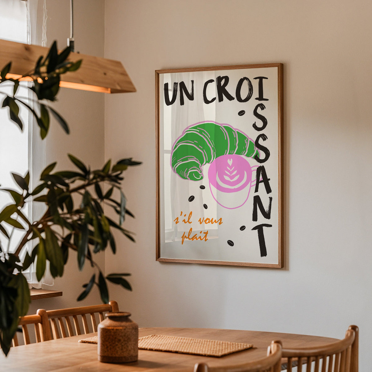 Un croissant french bakery print in a walnut frame above a table beside an olive tree