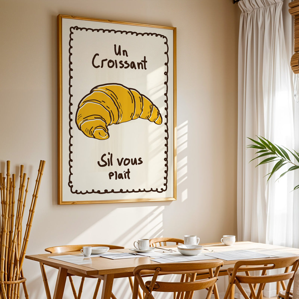 Un croissant yellow bakery print in a gold frame above a sunlit breakfast table