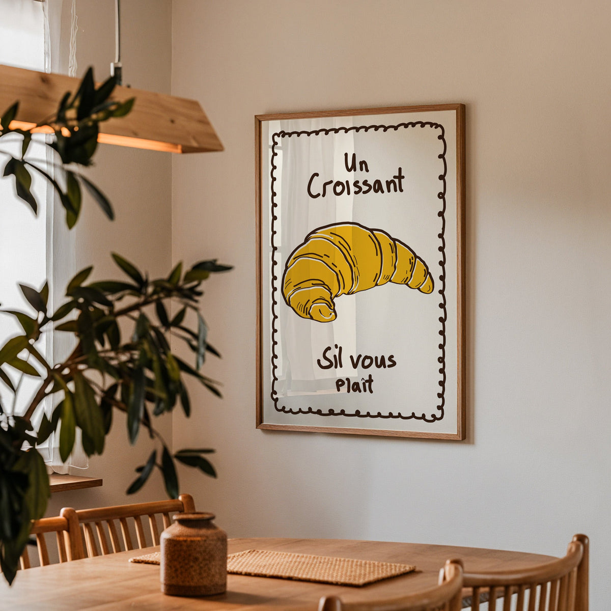 Un croissant yellow bakery print in a walnut frame above a table by an olive tree