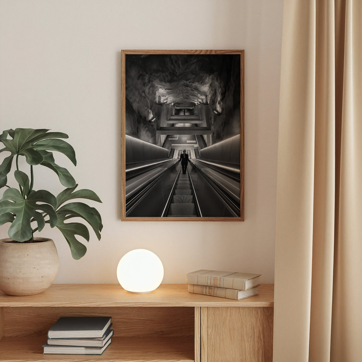 Black and white rock cave subway escalator print in a walnut frame above an oak cabinet with a glowing globe lamp
