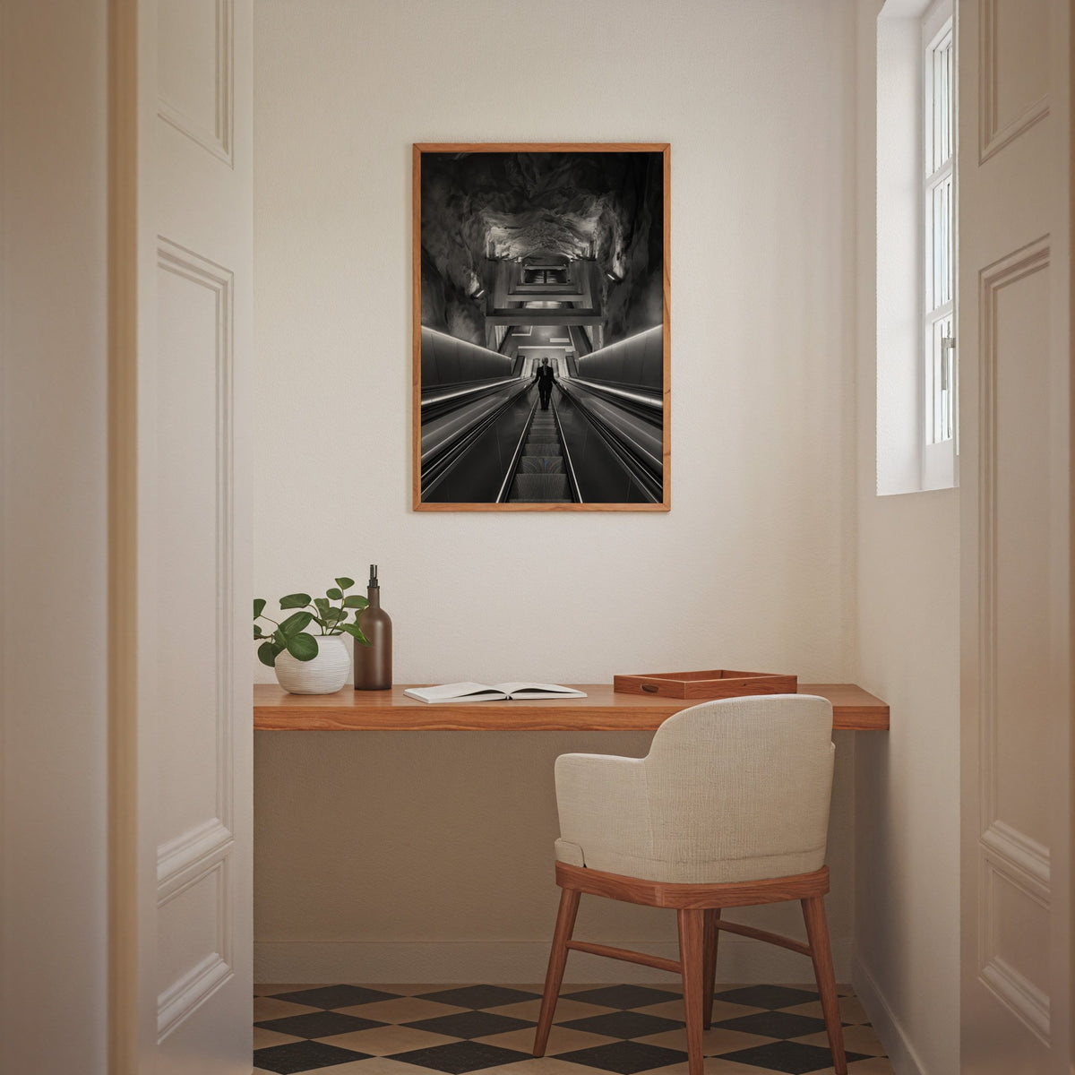 Black and white rock cave subway escalator print in an oak frame above a home office desk nook