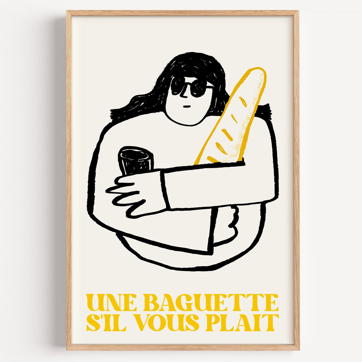 Une baguette french market print in a light oak frame on a plain white wall